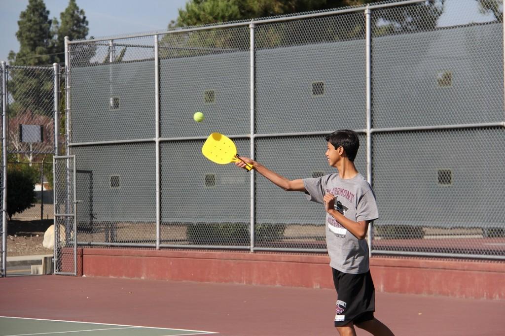 Freshman+Jesse+De+La+O+swings+his+racquet+in+an+attempt+to+hit+the+wiffleball+in+a+pickleball+match.