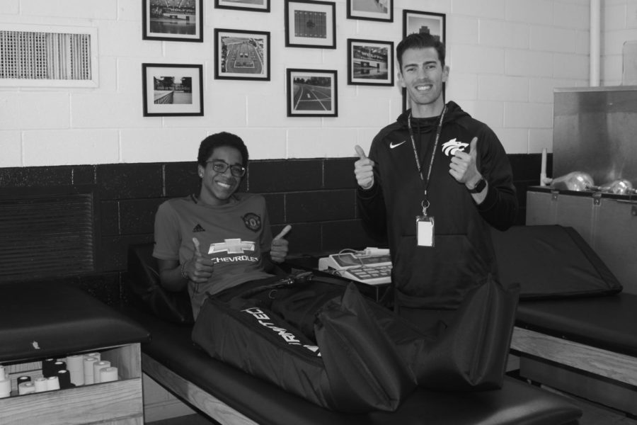 CHS junior Nathan Ball and athletic trainer Jonathan Snapp, pictured left, using the new NormaTec compression boots.