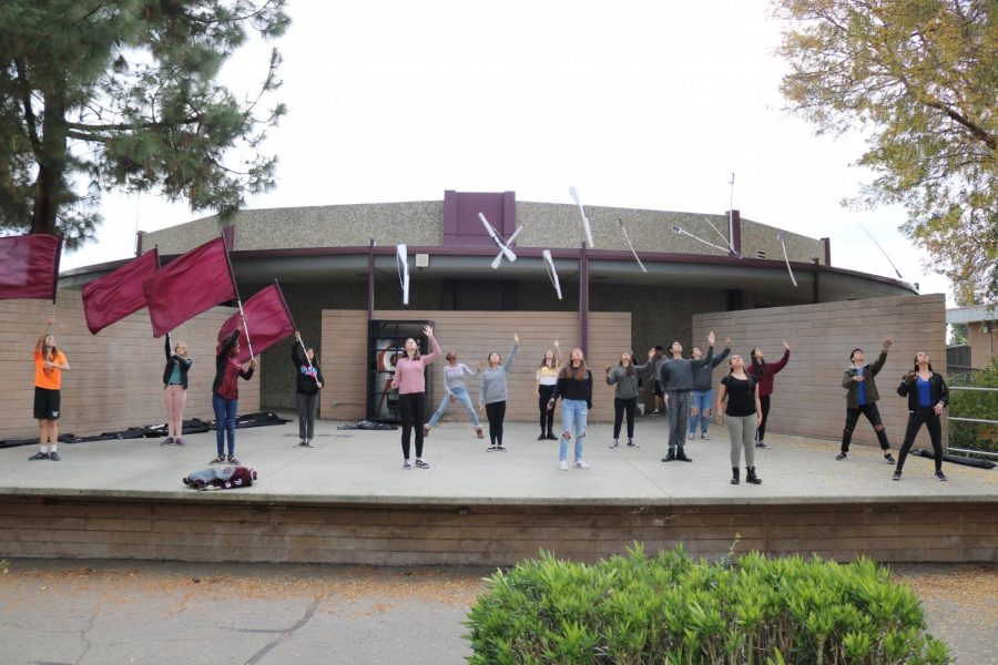 Students in the color guard practice on the band stage during the school period allocated to them for training. At other schools, sports teams get periods to train during the school day.