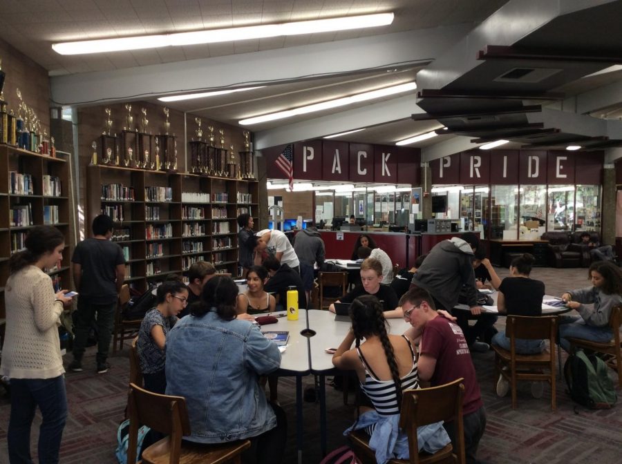 CGT tutors in the CHS library working with their tutees on homework and reviewing notes.