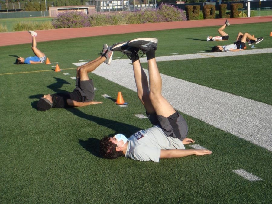 Junior Xavier Ascencio (center right), freshman Nicky Venegas (center left), and other cross-country runners complete a core routine during their practice on Saturday.