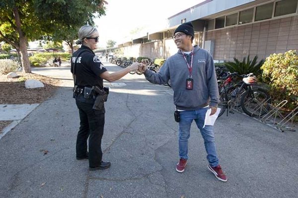 School resource officer corporal Brittany Sornborger greets proctor Lucky Duong at Claremont High School.